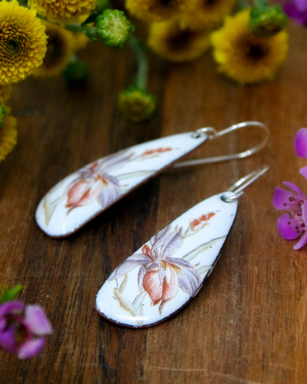 a pair of earrings sitting on top of a wooden table