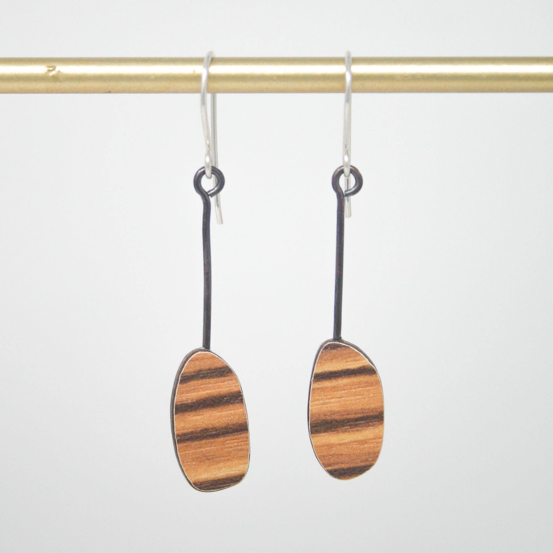 a pair of wooden earrings hanging from a hook
