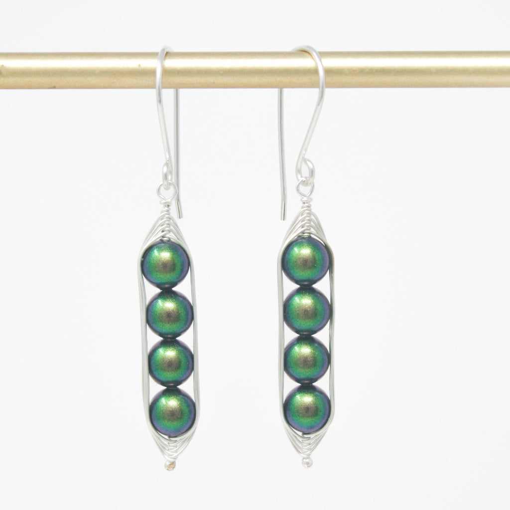 a pair of earrings with green beads hanging from them