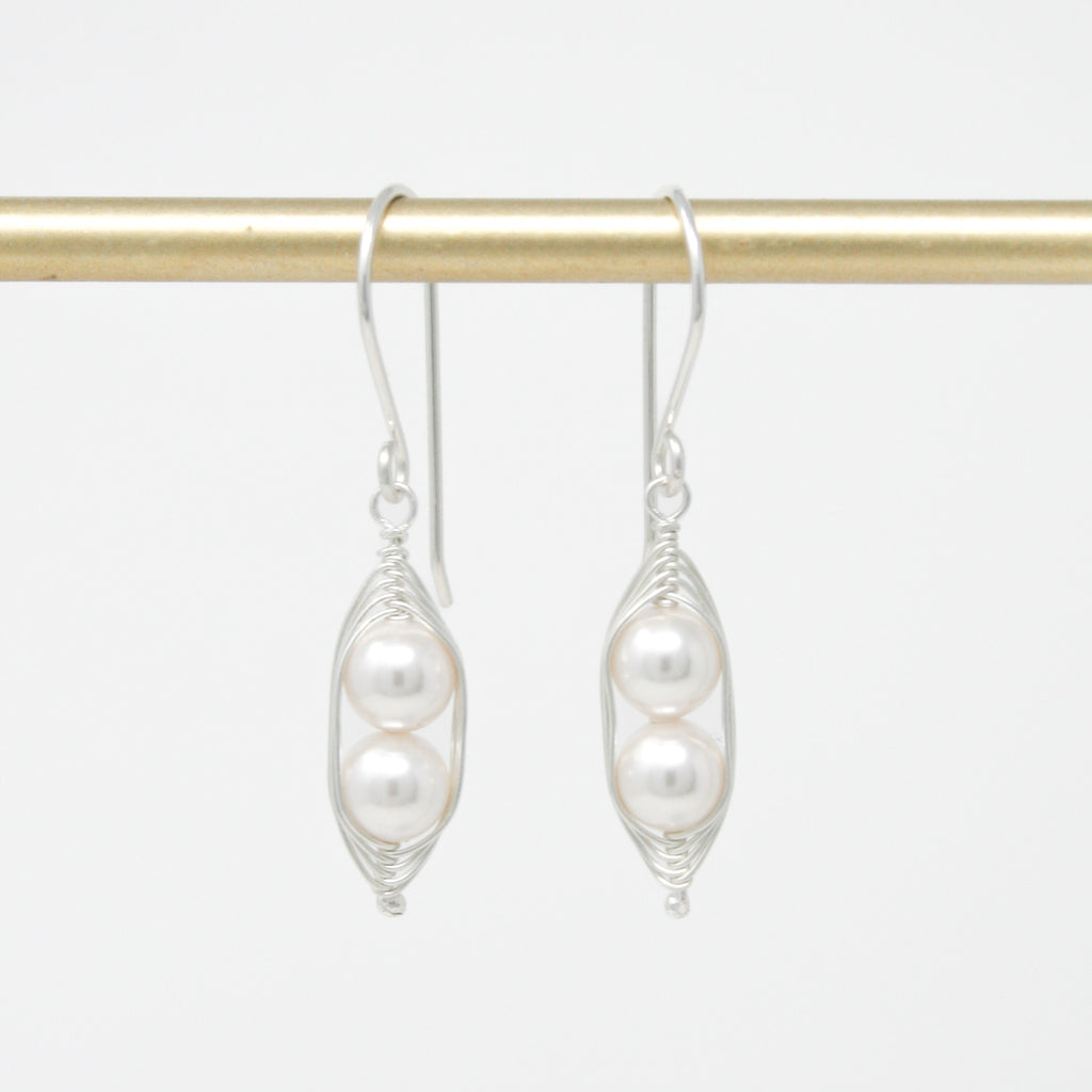a pair of white pearls hanging from a hook