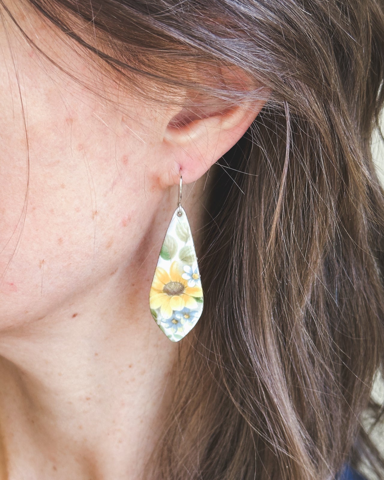 a close up of a person wearing a pair of earrings