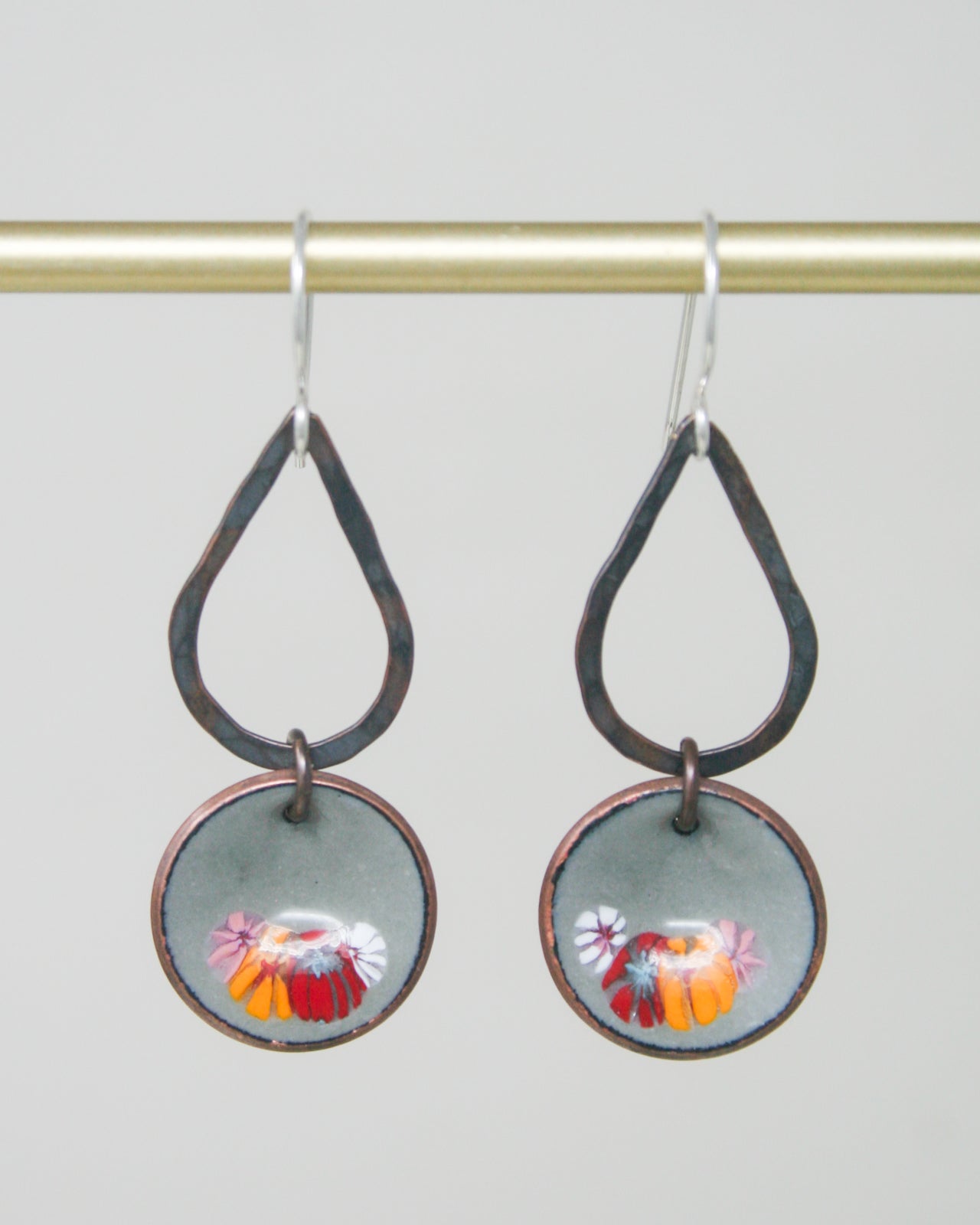 a pair of earrings hanging from a hook