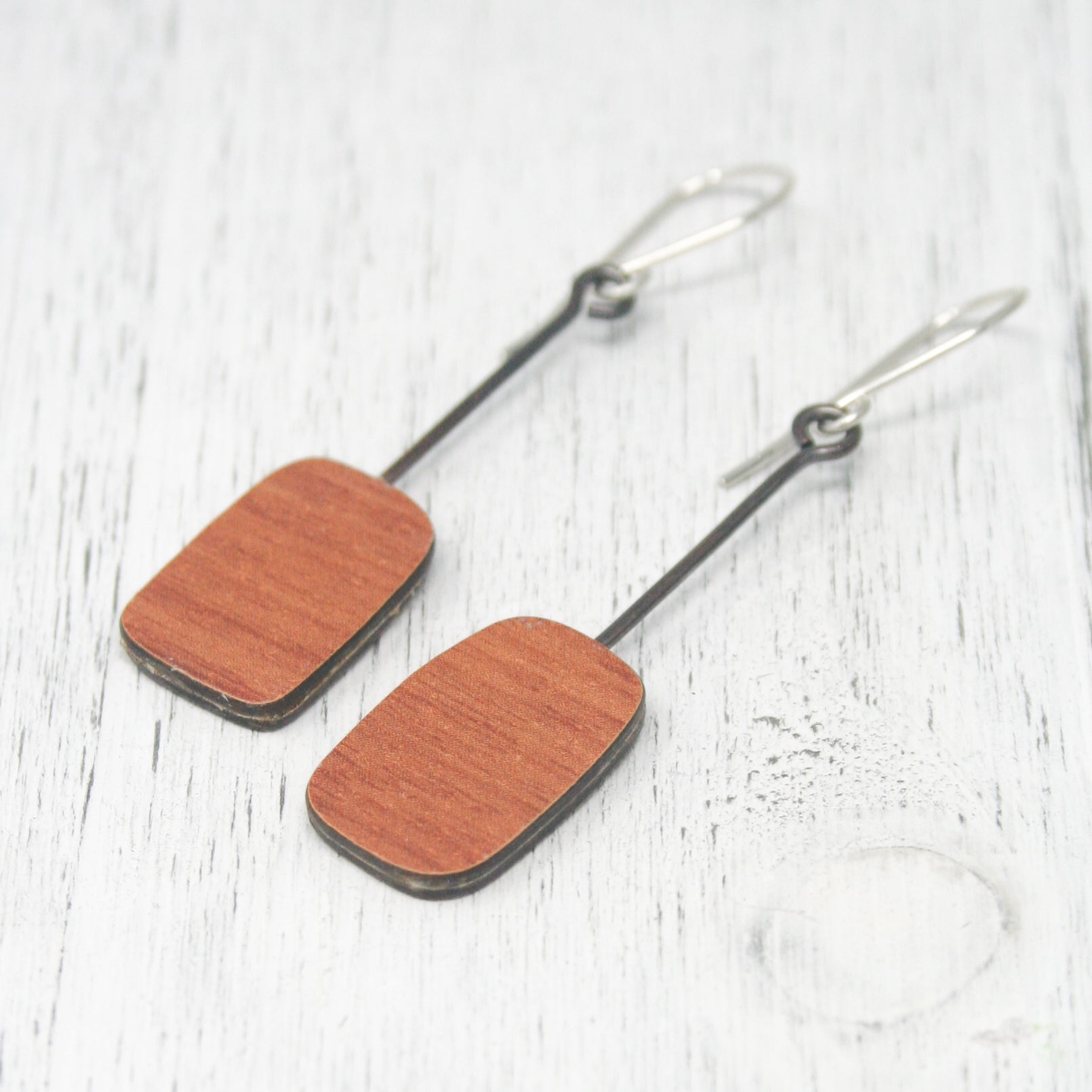 a pair of wooden earrings hanging from a hook