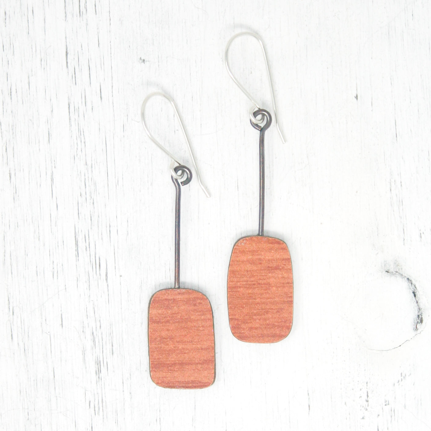 a pair of wooden earrings hanging from hooks