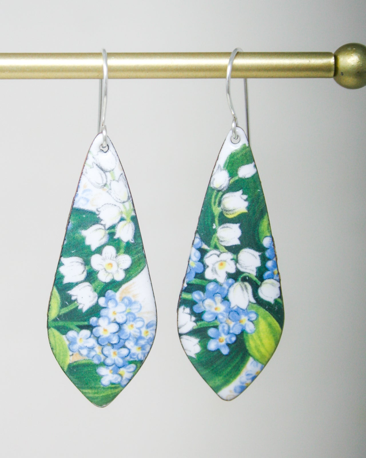 a pair of earrings with flowers painted on them