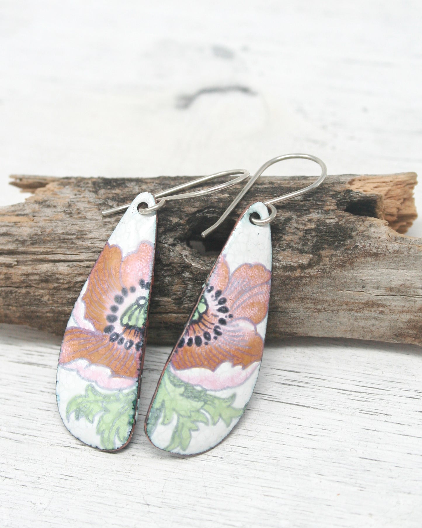 a pair of earrings with flowers painted on them