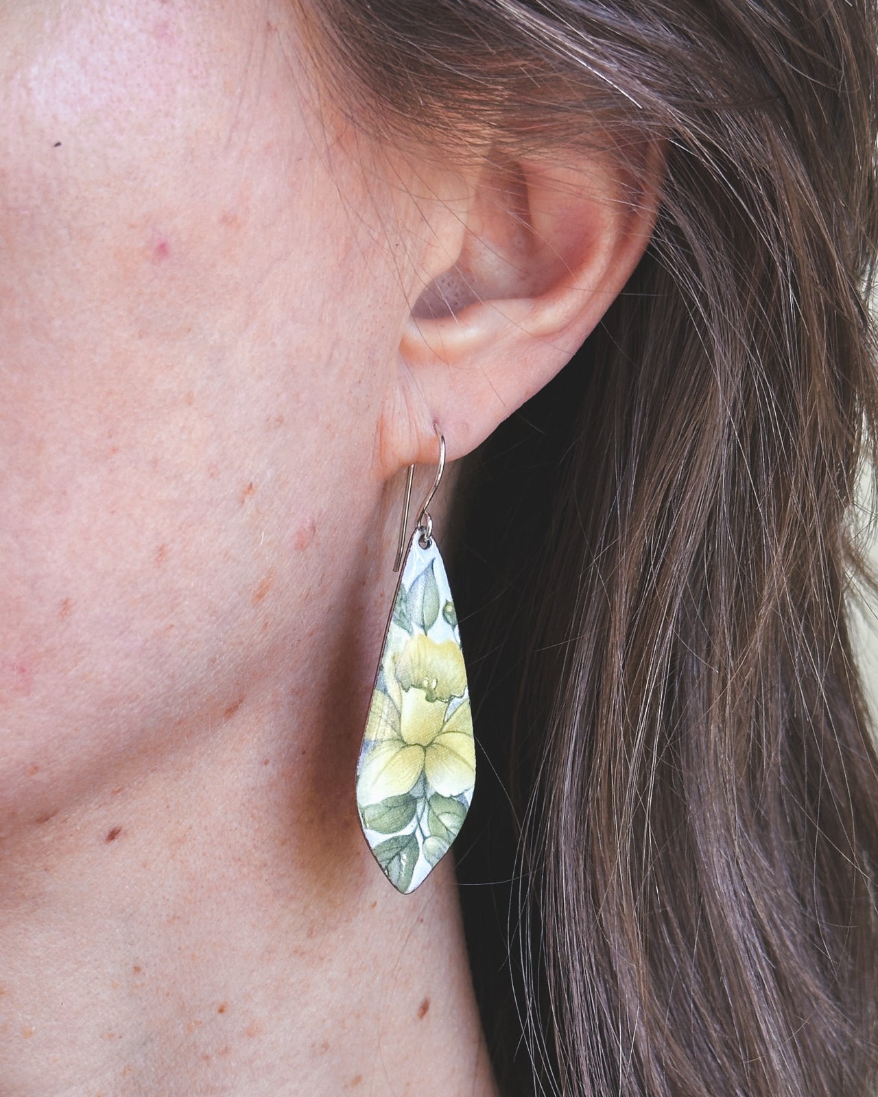 a close up of a person wearing a pair of earrings