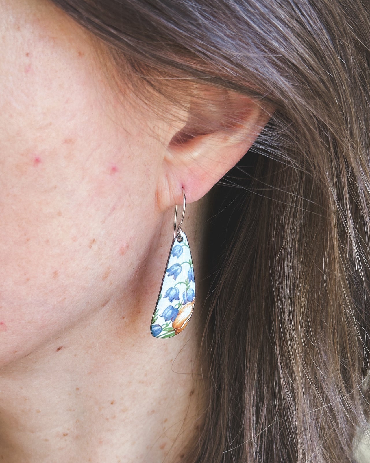 a close up of a person wearing a pair of earrings