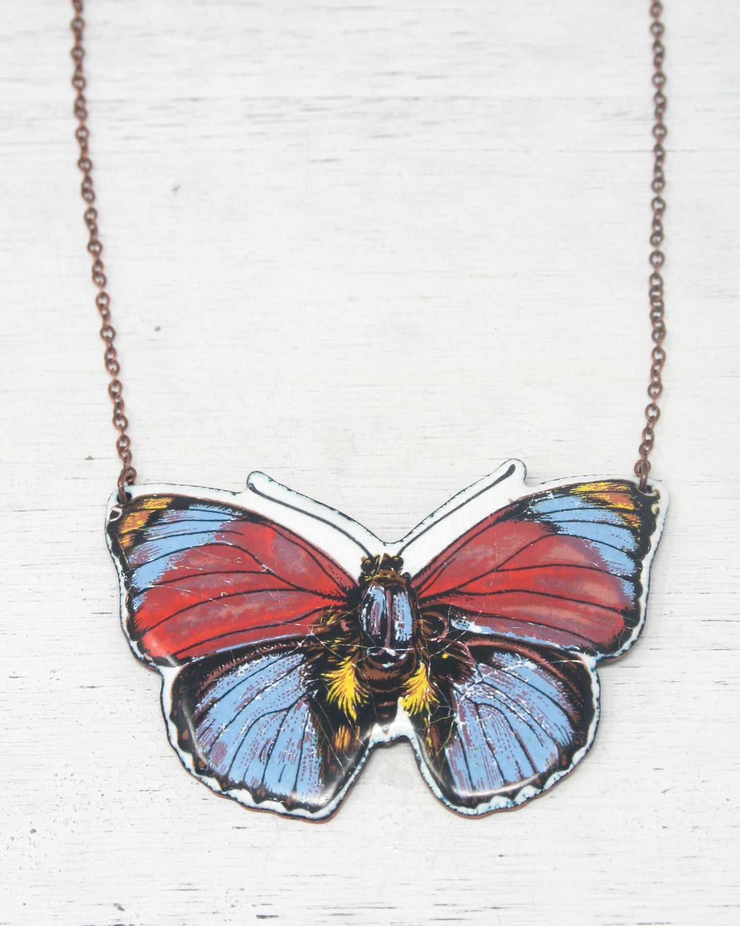 a necklace with a butterfly on a chain