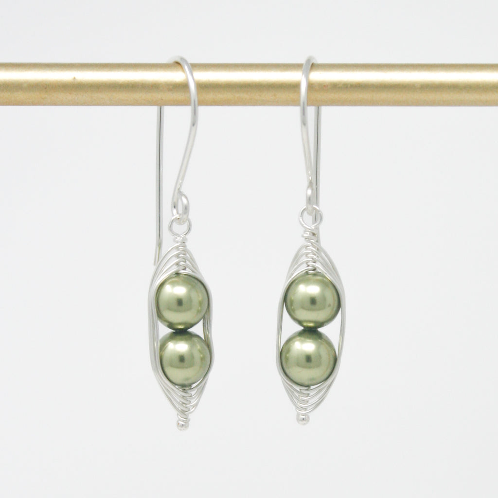 a pair of earrings with pearls hanging from them