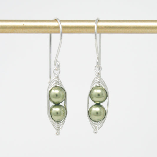 a pair of earrings with pearls hanging from them