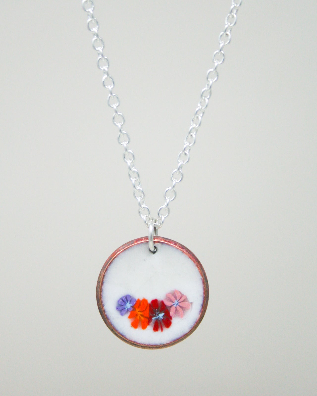 A necklace with a circular pendant featuring a floral design.