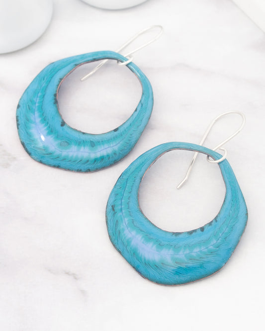 A pair of turquoise earrings with a unique, textured design.