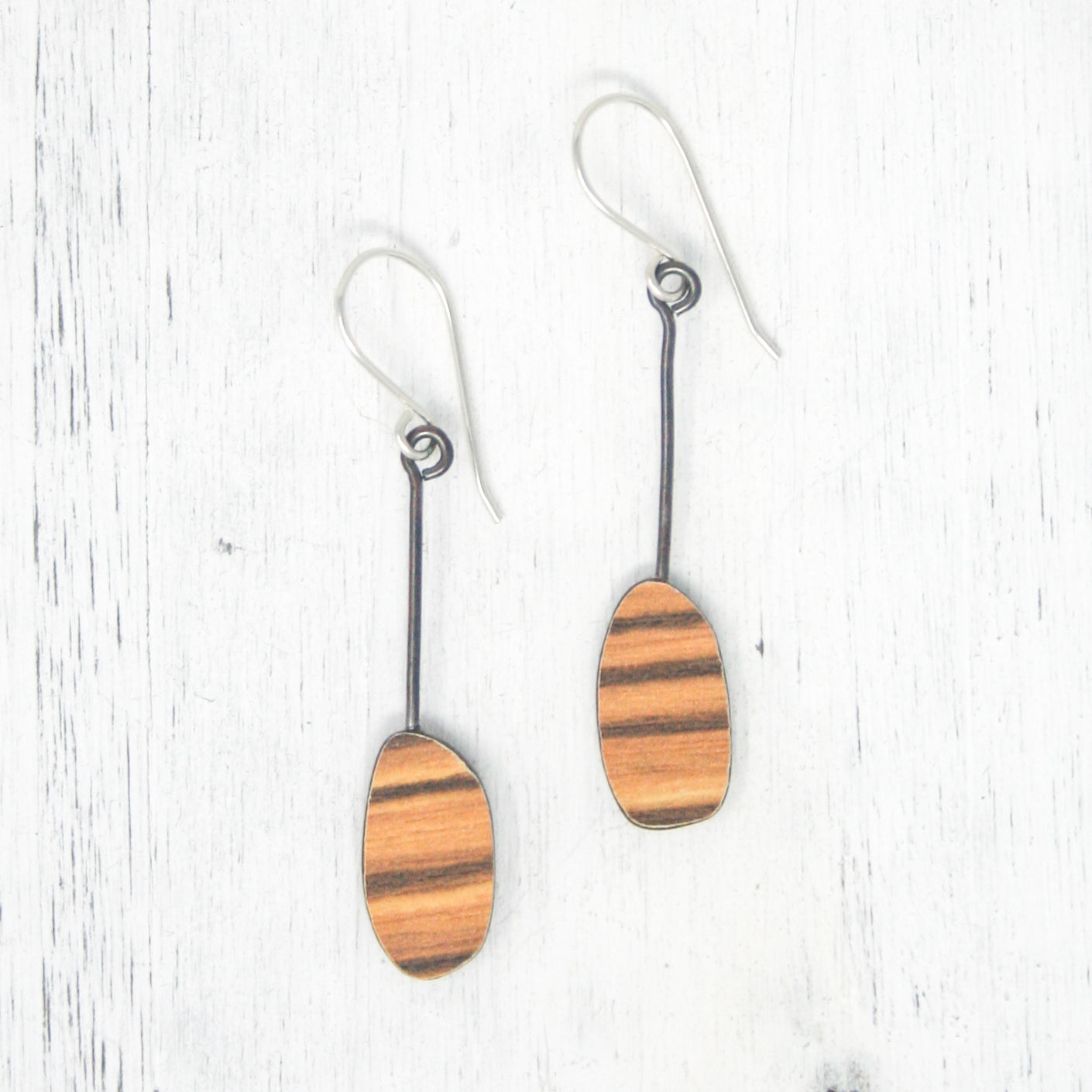 a pair of wooden earrings on a white background