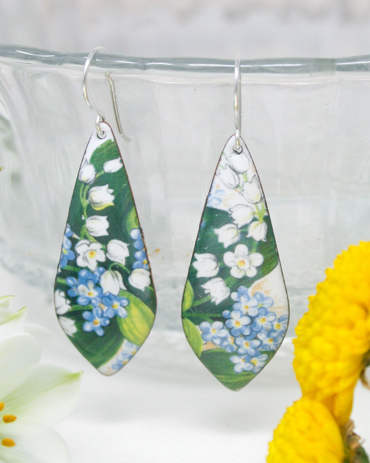 a pair of earrings with flowers painted on them