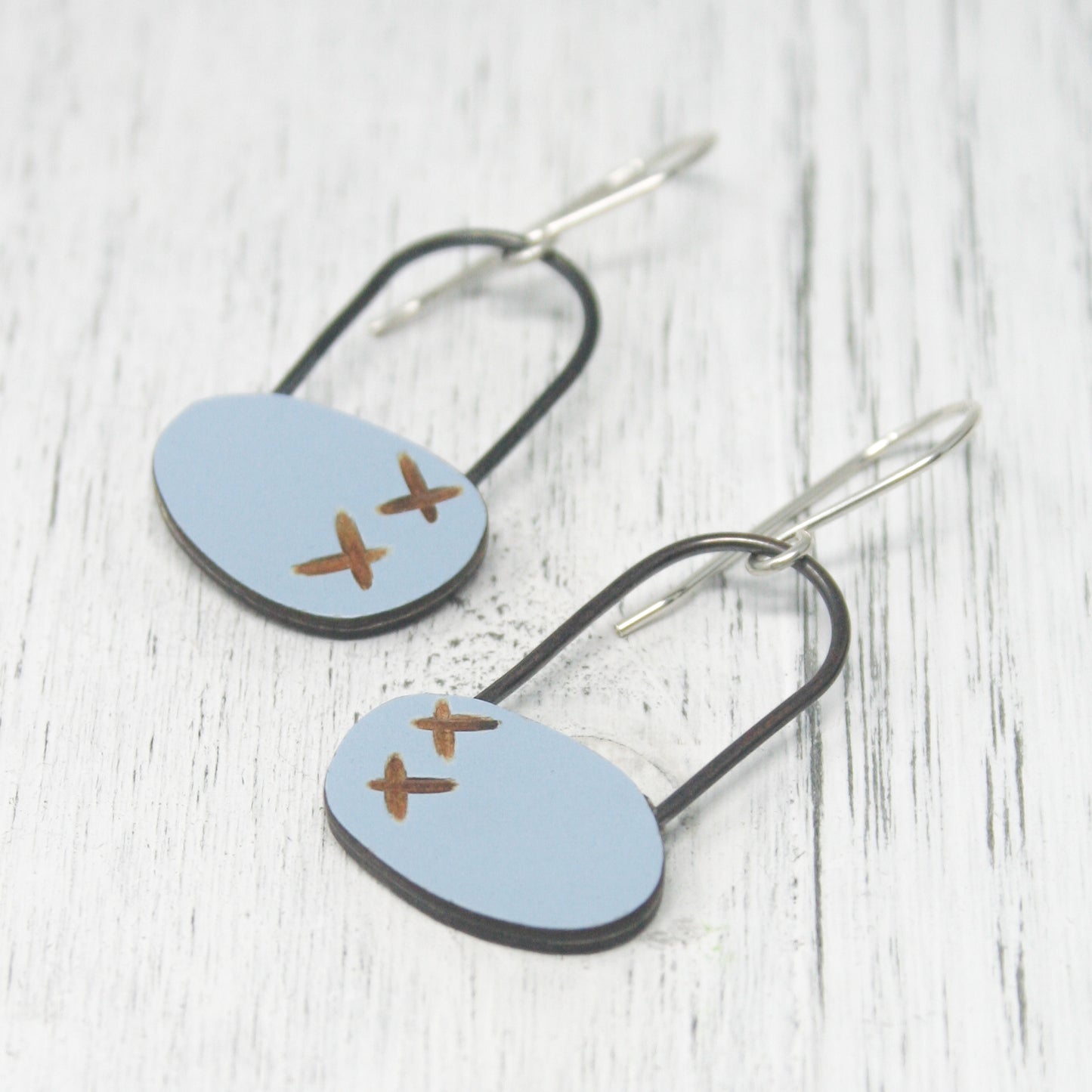 a pair of earrings with a plane painted on them