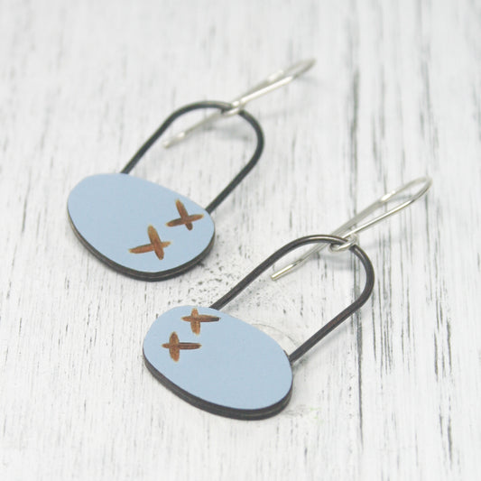 a pair of earrings with a plane painted on them