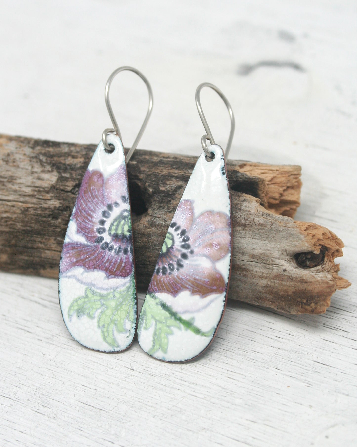 a pair of earrings with flowers painted on them