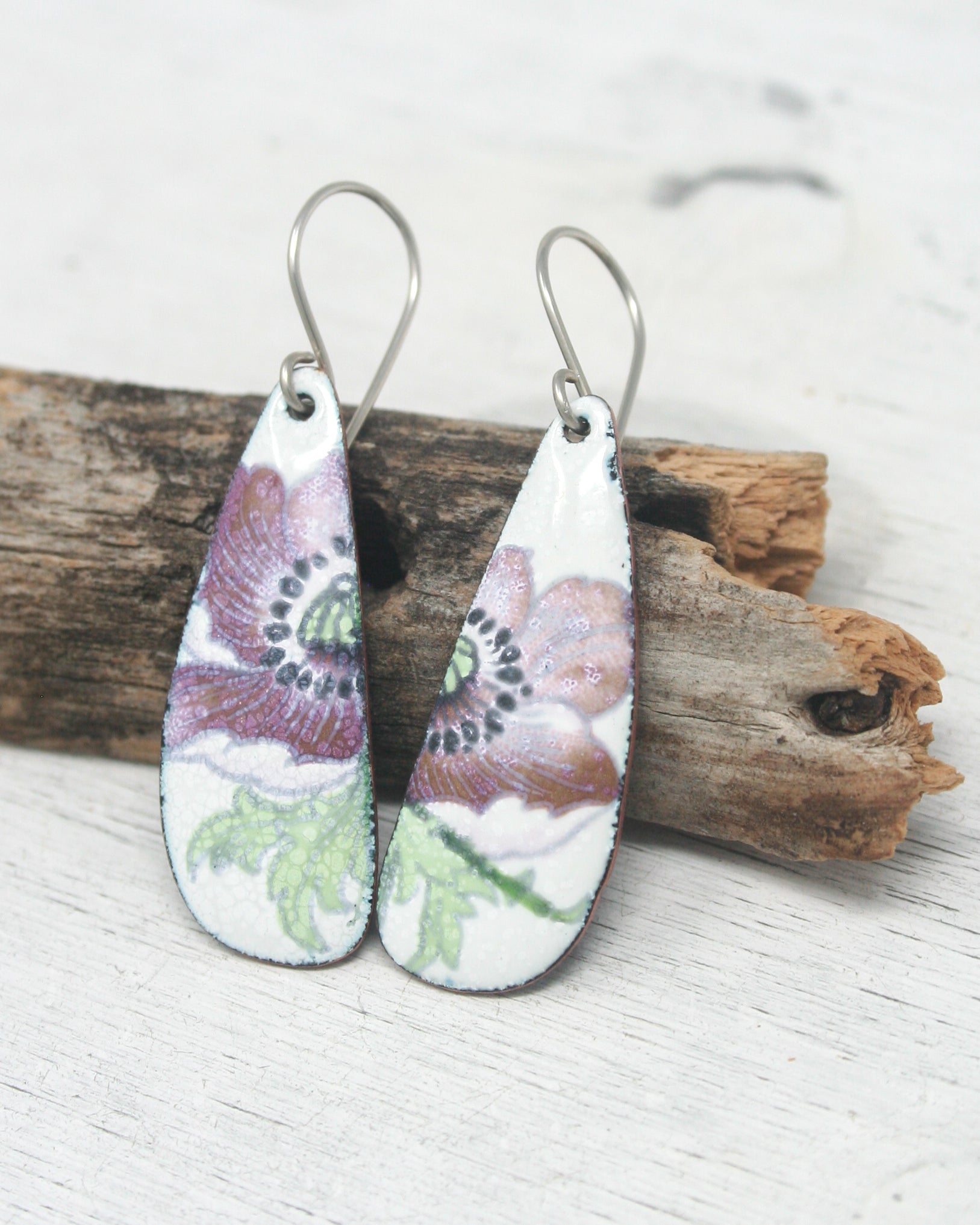 a pair of earrings with flowers painted on them