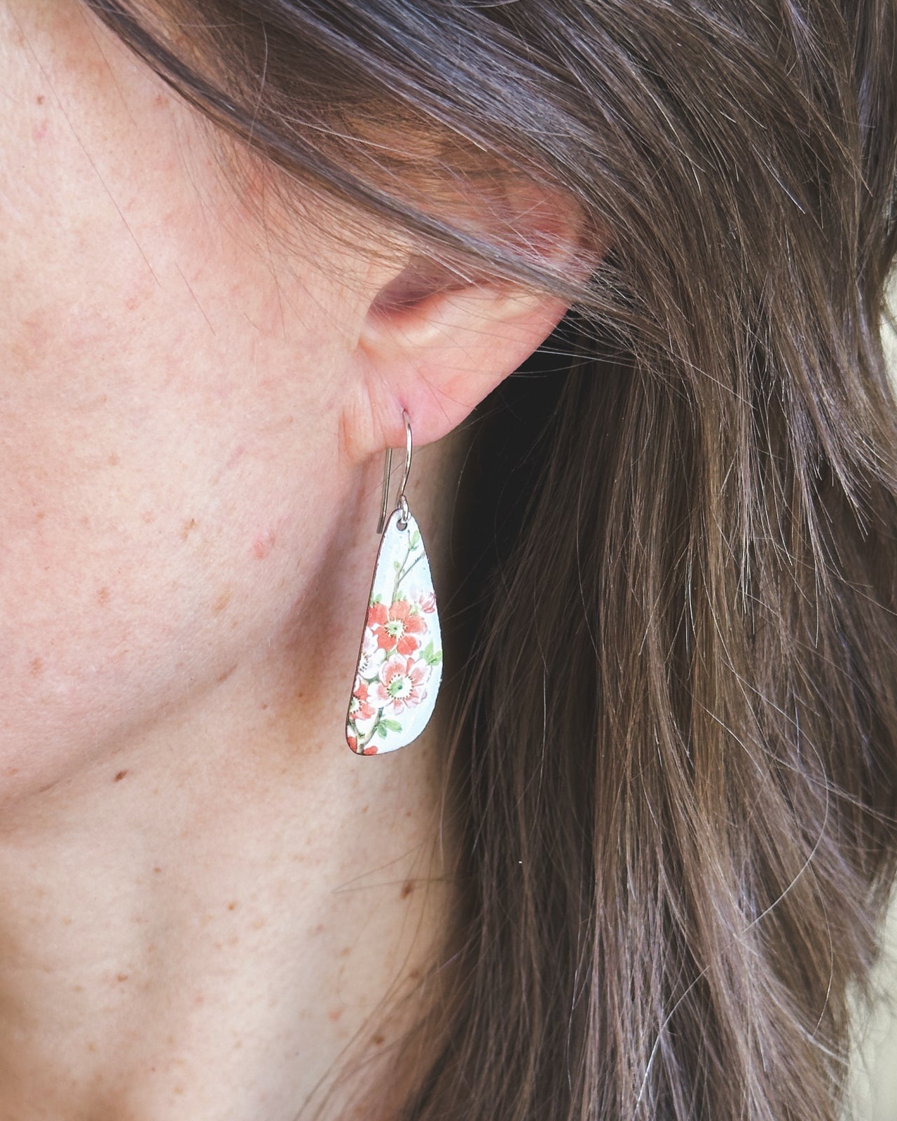 a close up of a person wearing a pair of earrings