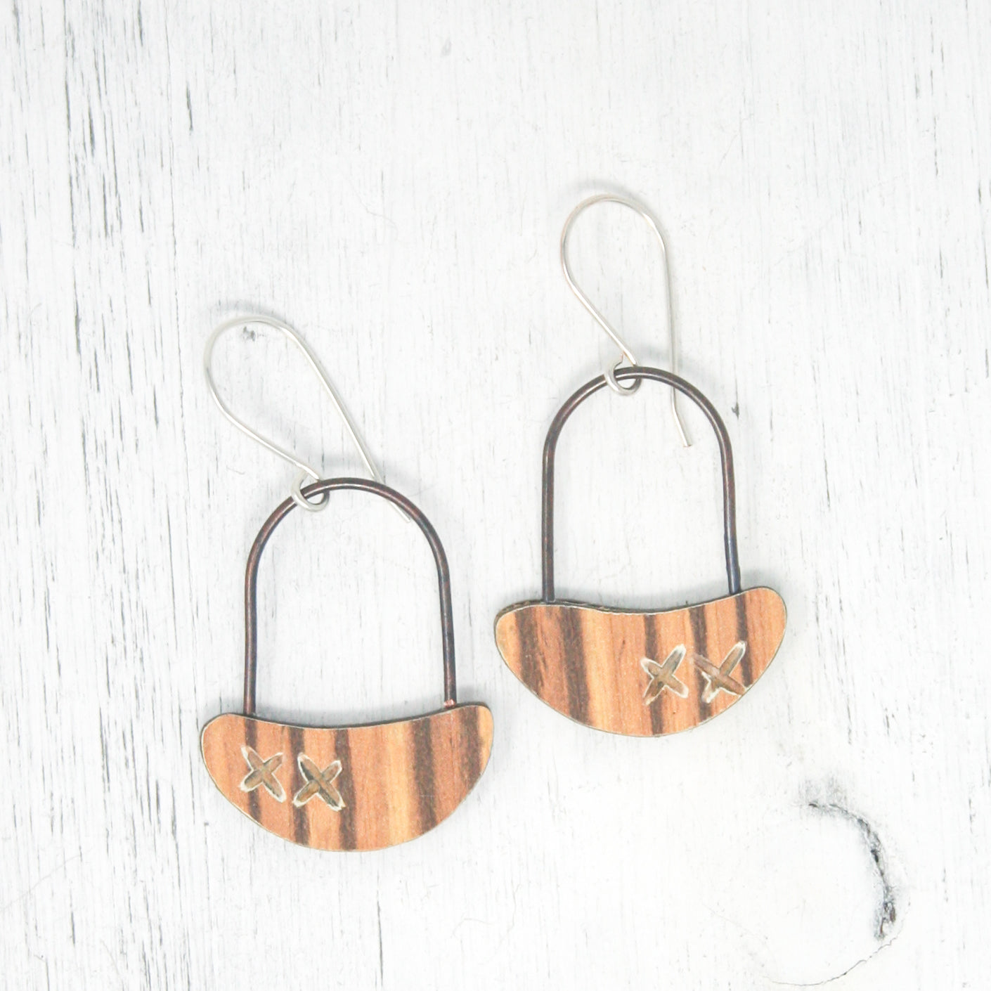 a pair of wooden earrings hanging from a hook