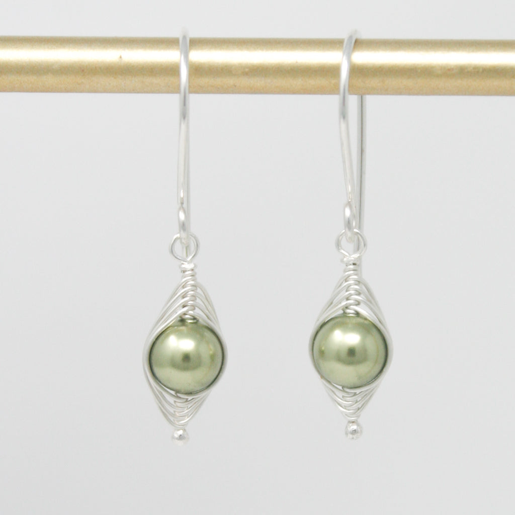 a pair of silver earrings with a green pearl