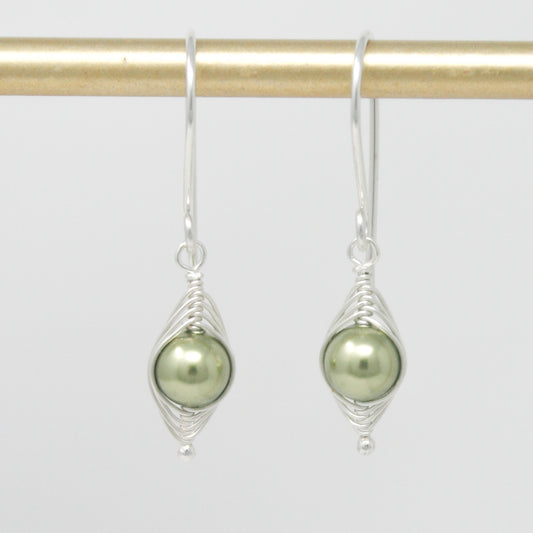 a pair of silver earrings with a green pearl