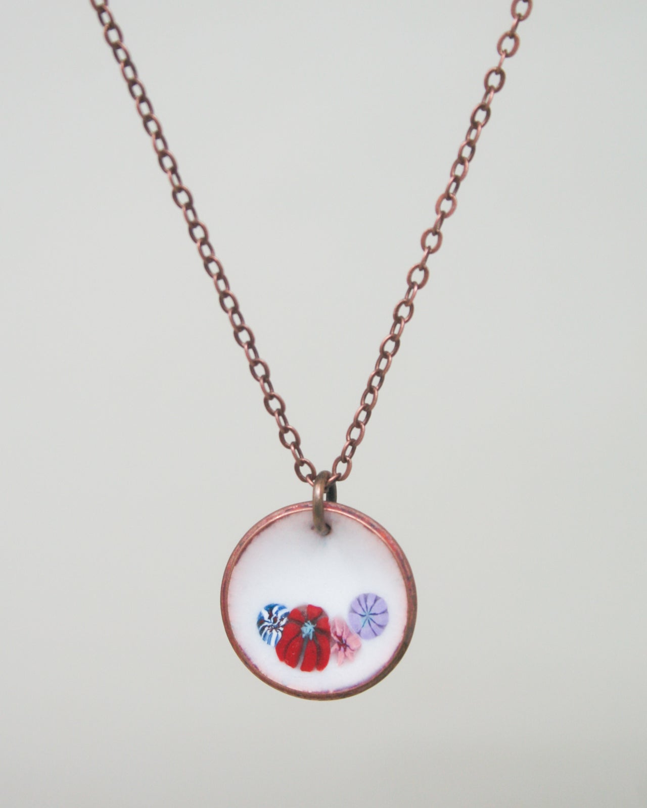 a necklace that has a picture of two birds on it