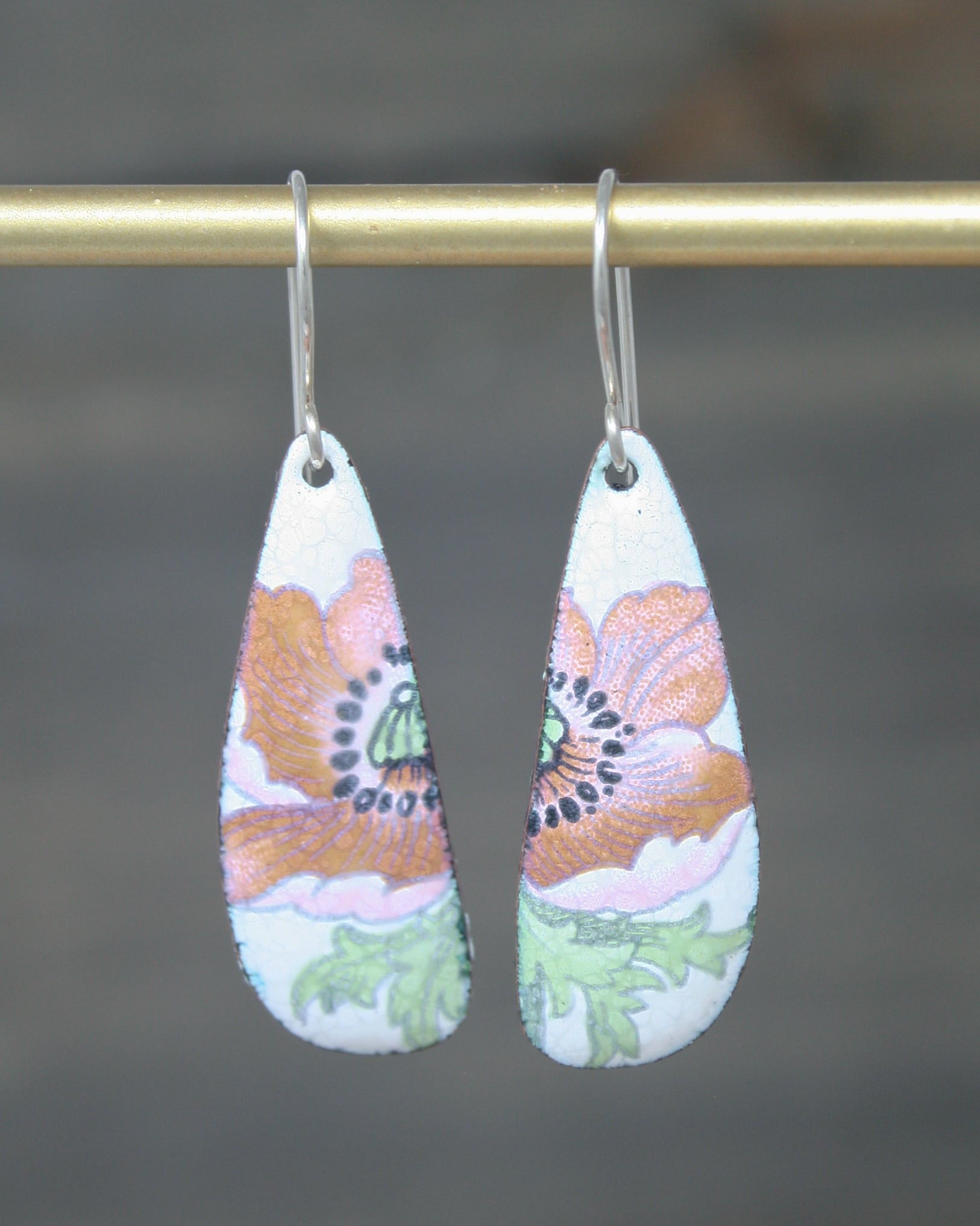 a pair of earrings hanging from a hook
