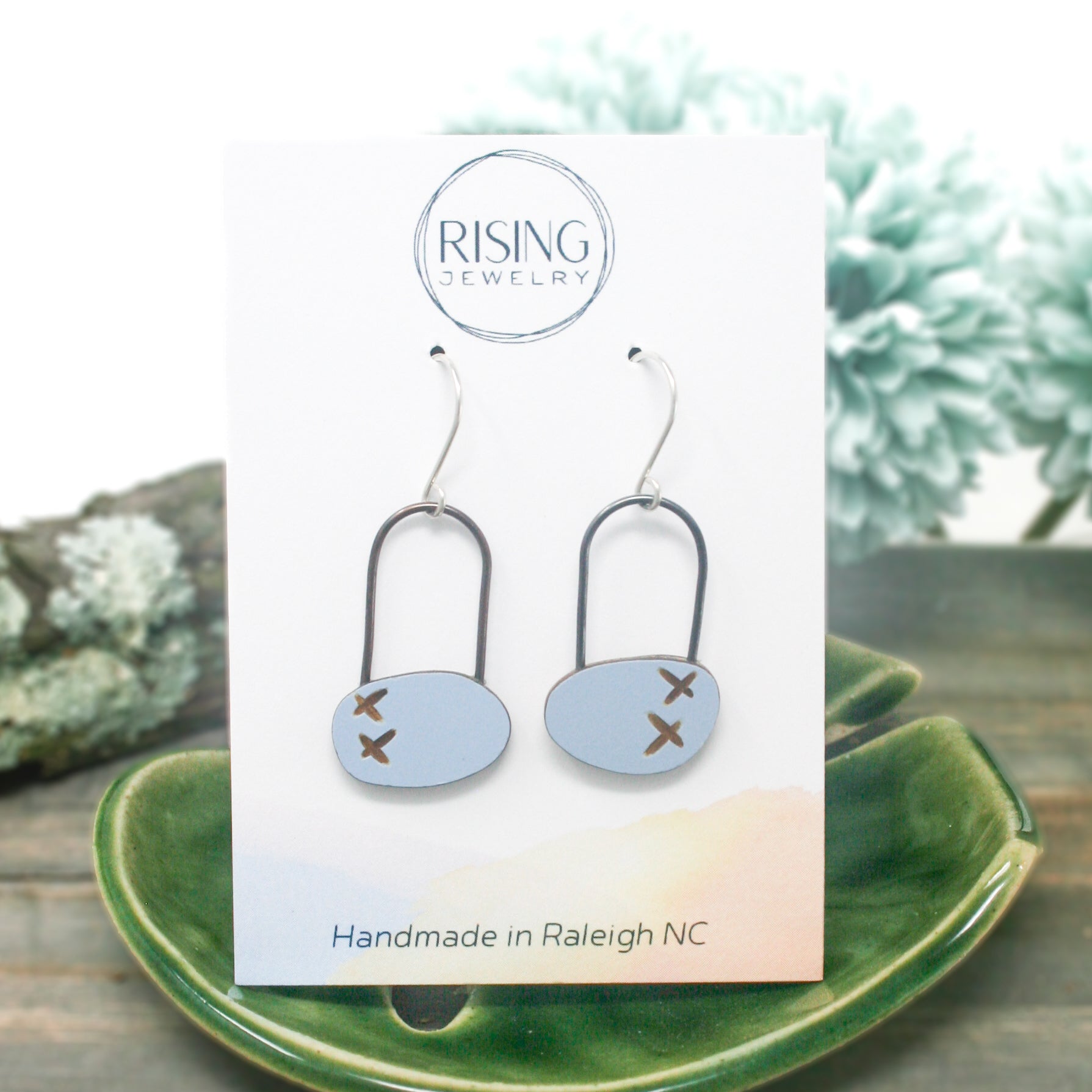 a pair of earrings sitting on top of a green plate
