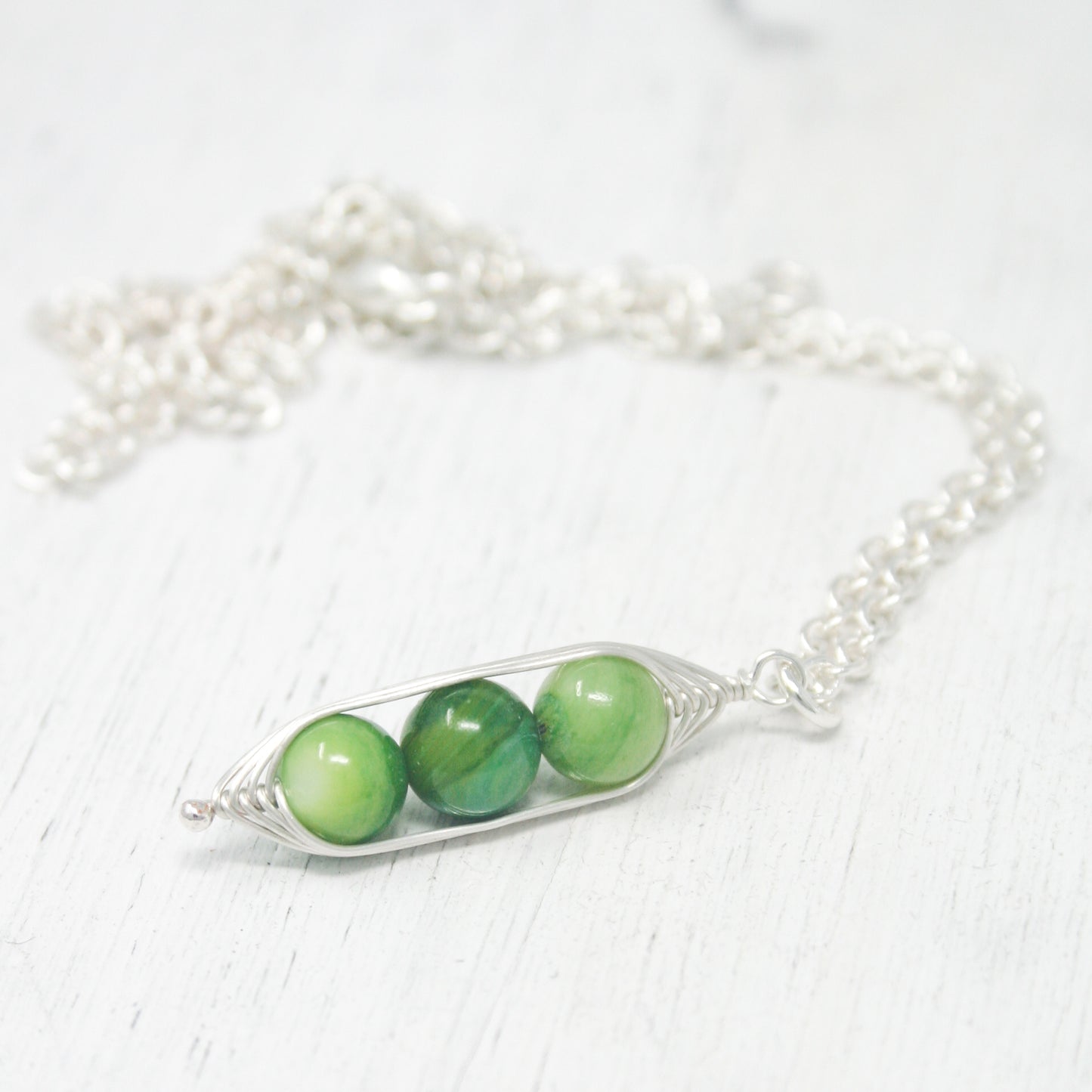 two peas in a pod on a silver chain