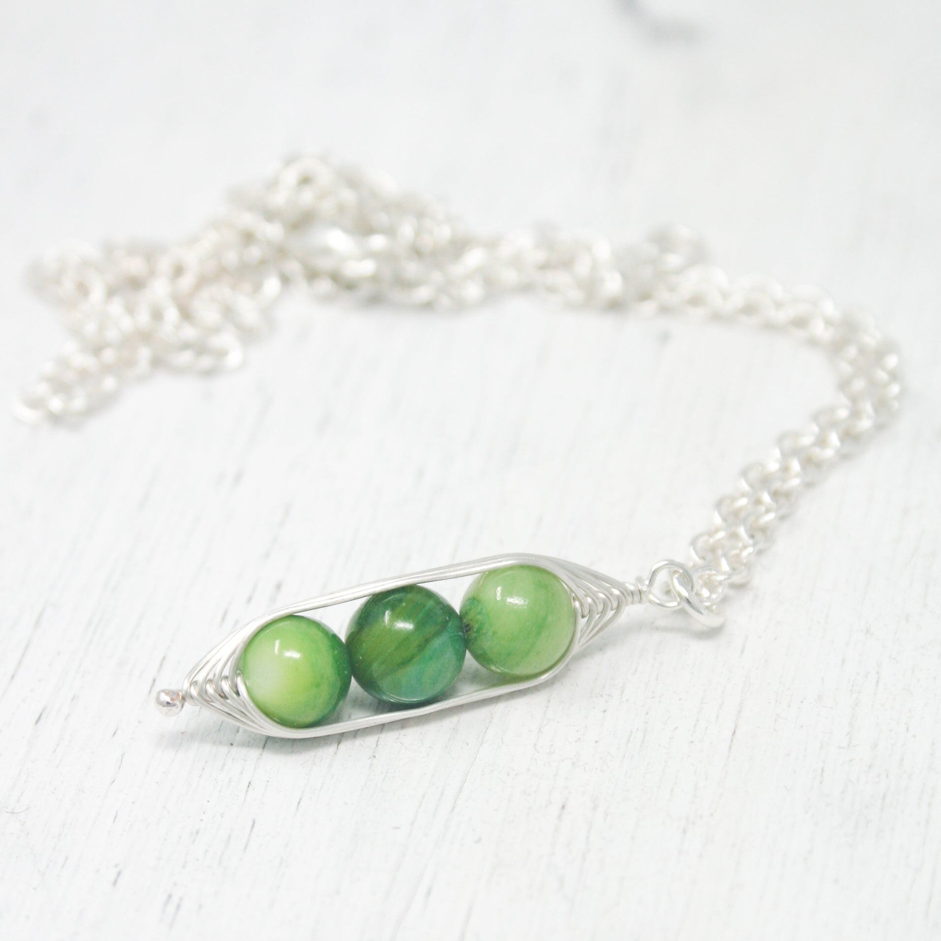 two peas in a pod on a silver chain