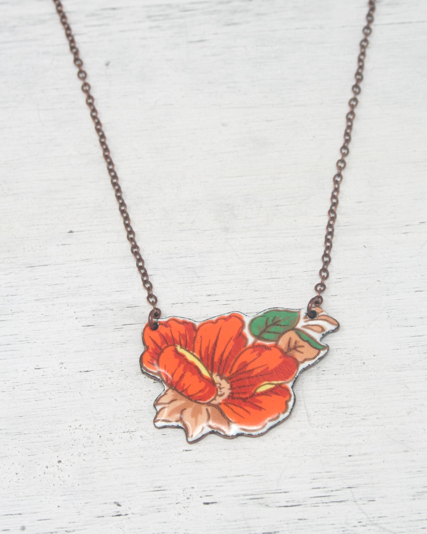 a necklace with a flower painted on it