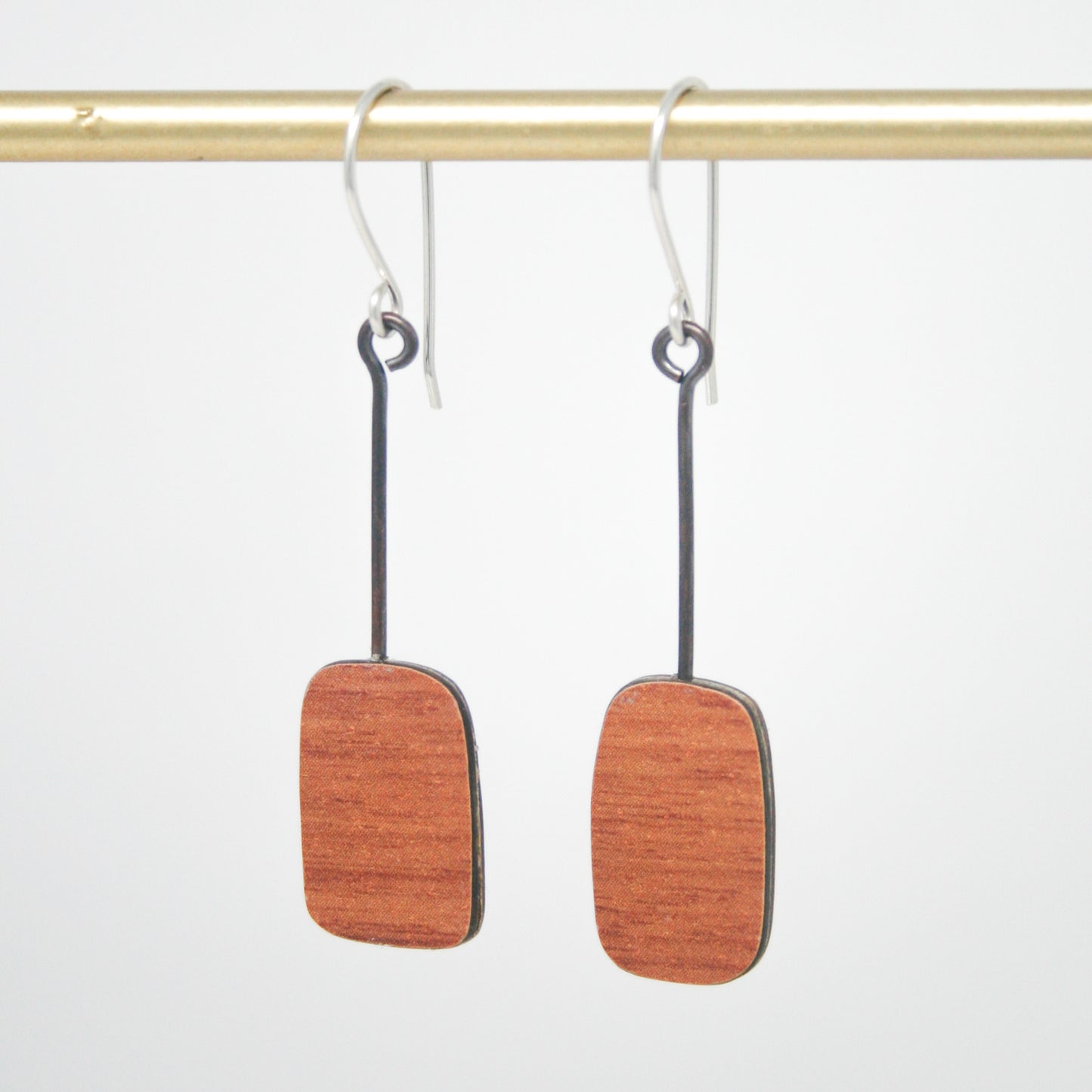 a pair of wooden earrings hanging from a hook