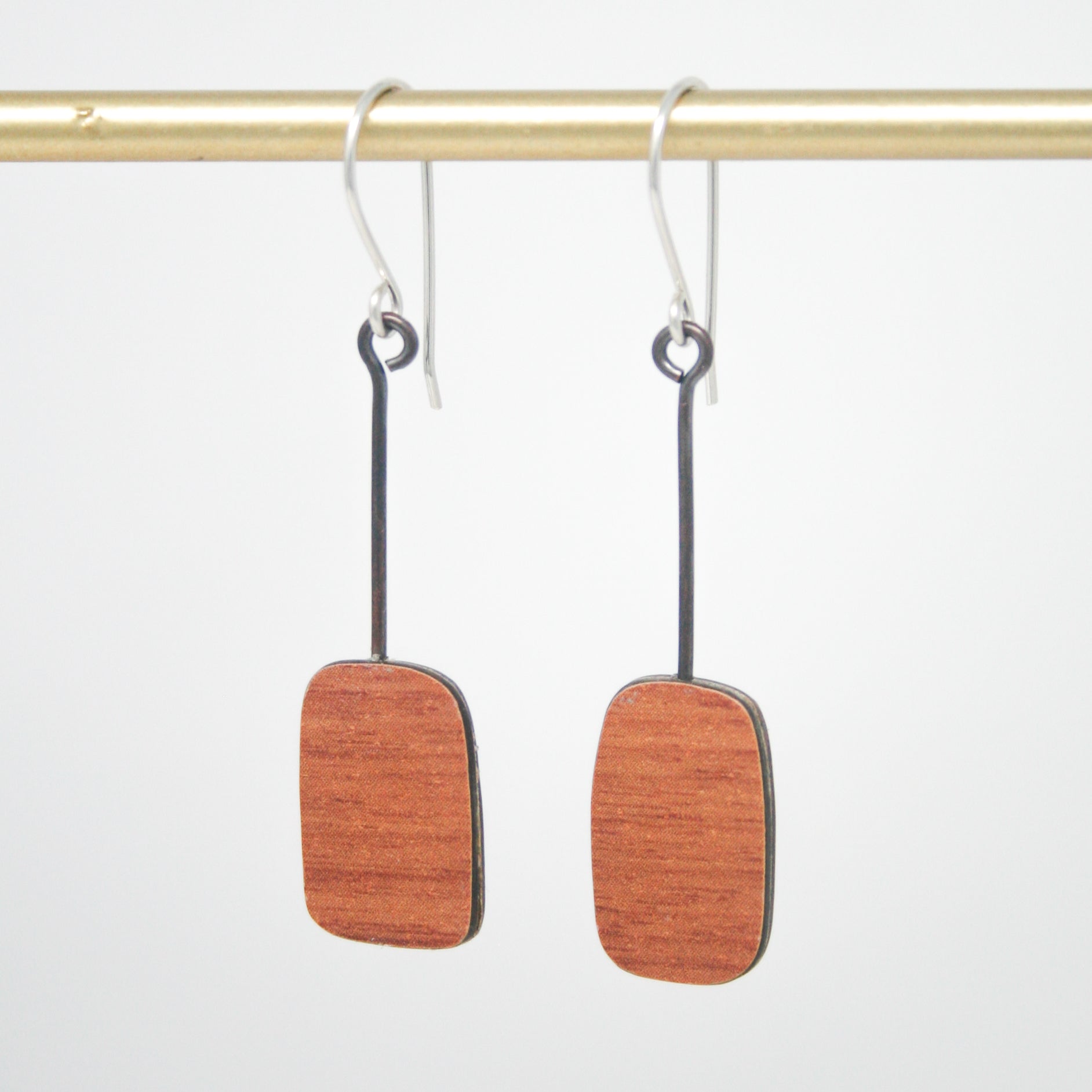 a pair of wooden earrings hanging from a hook