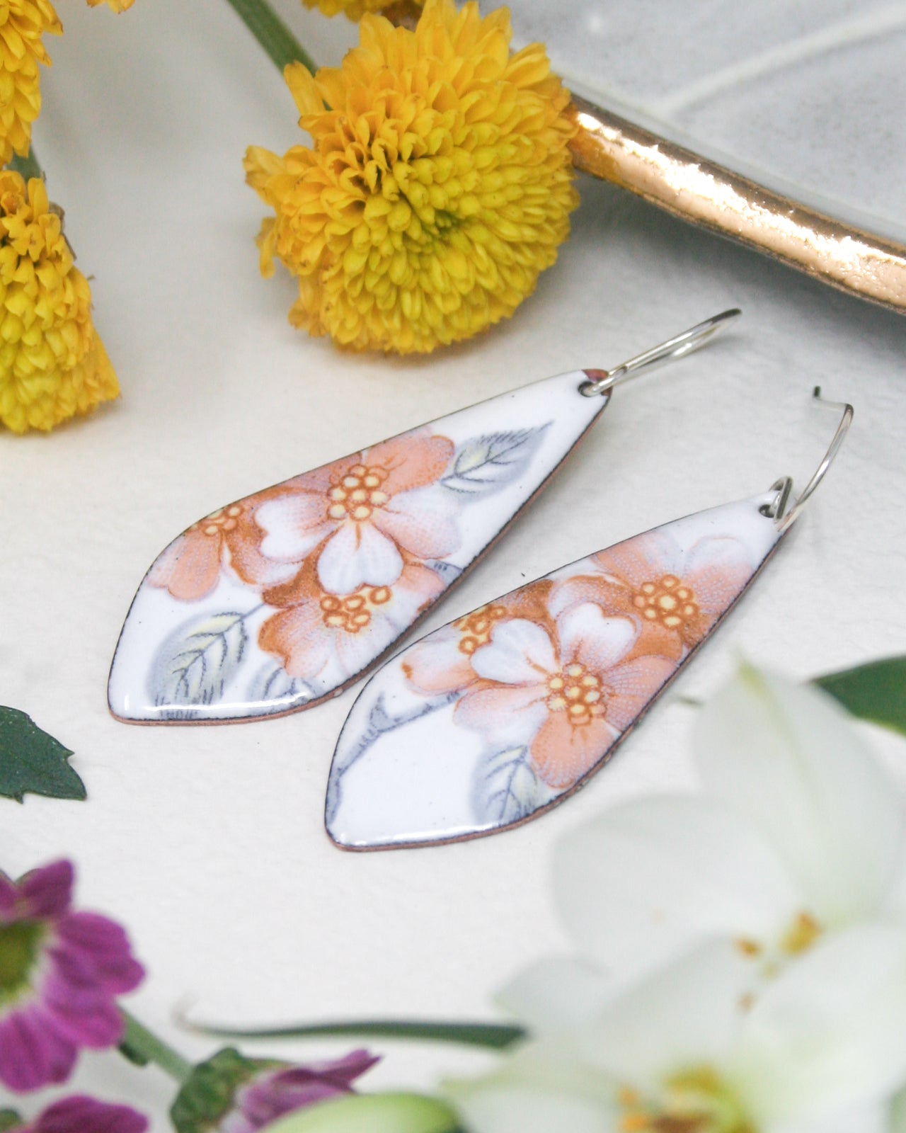 a pair of earrings with flowers on them
