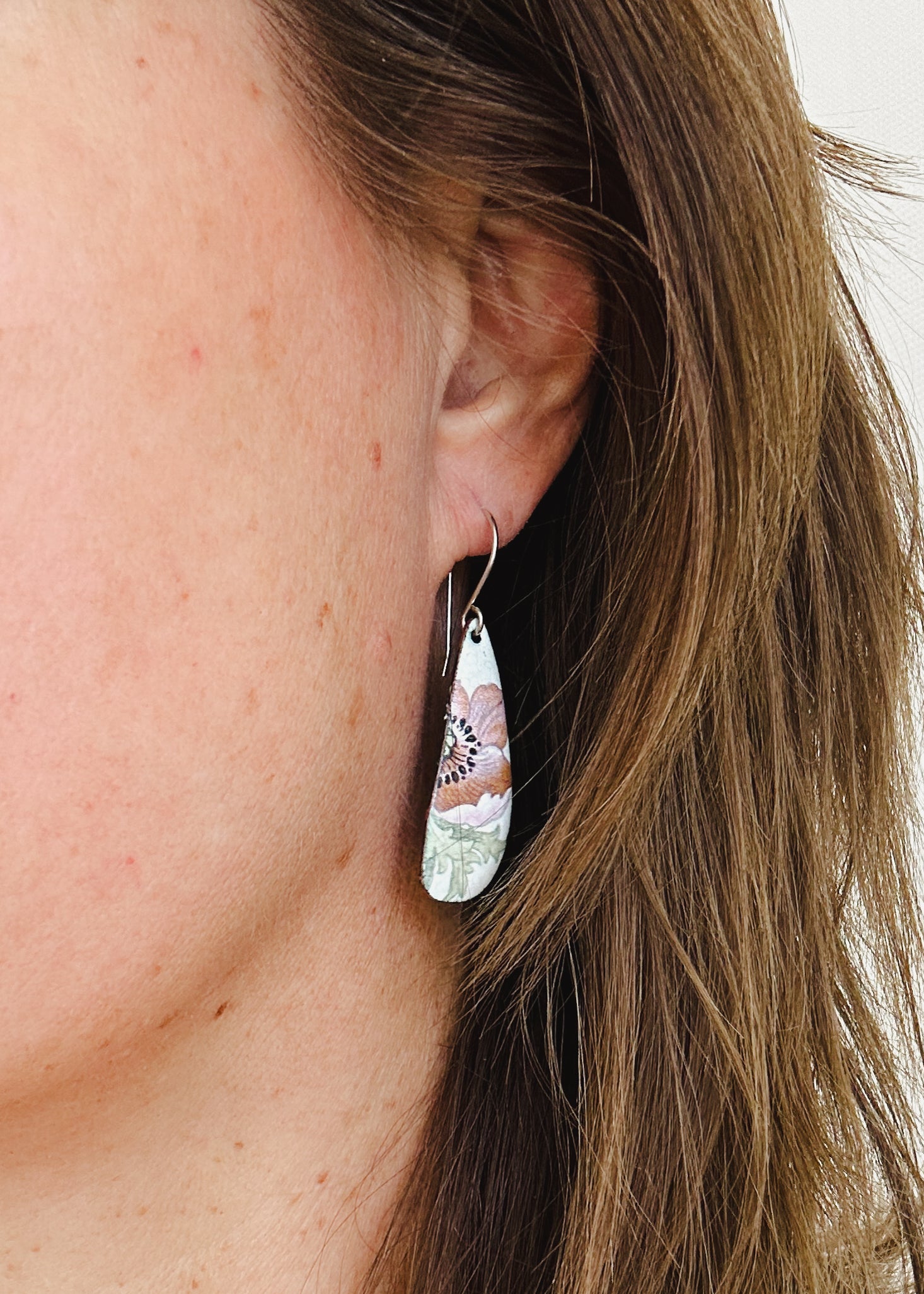 a close up of a person wearing a pair of earrings