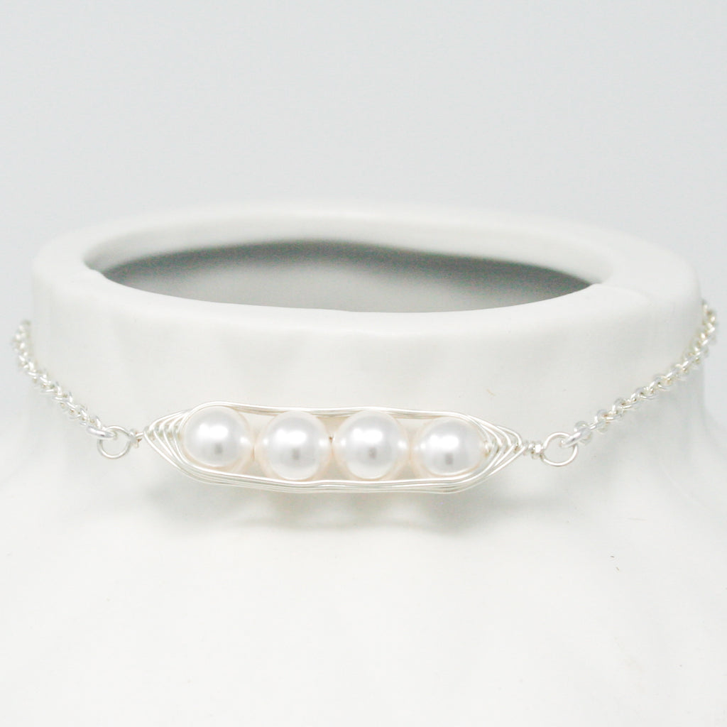a close up of a white vase with a necklace on it