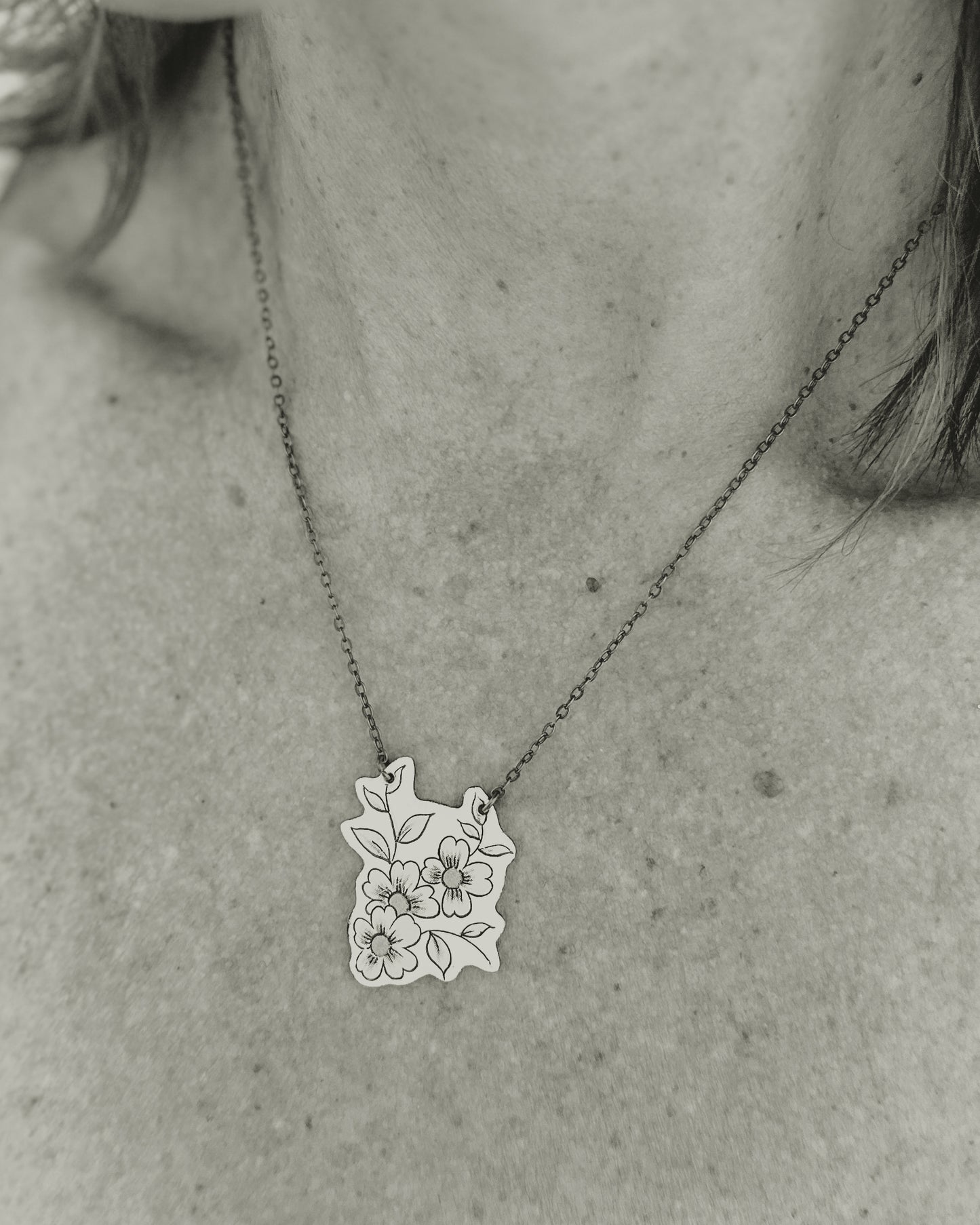 a woman wearing a necklace with flowers on it