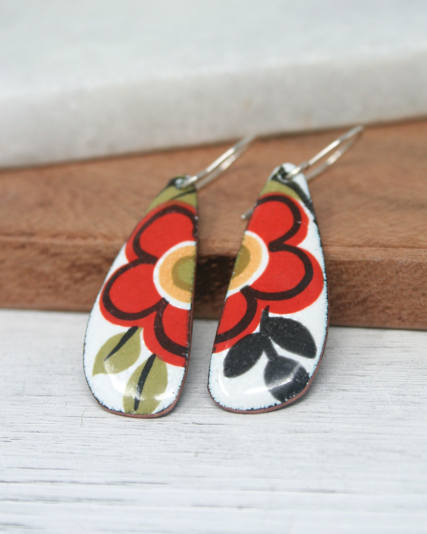 a pair of earrings with flowers painted on them