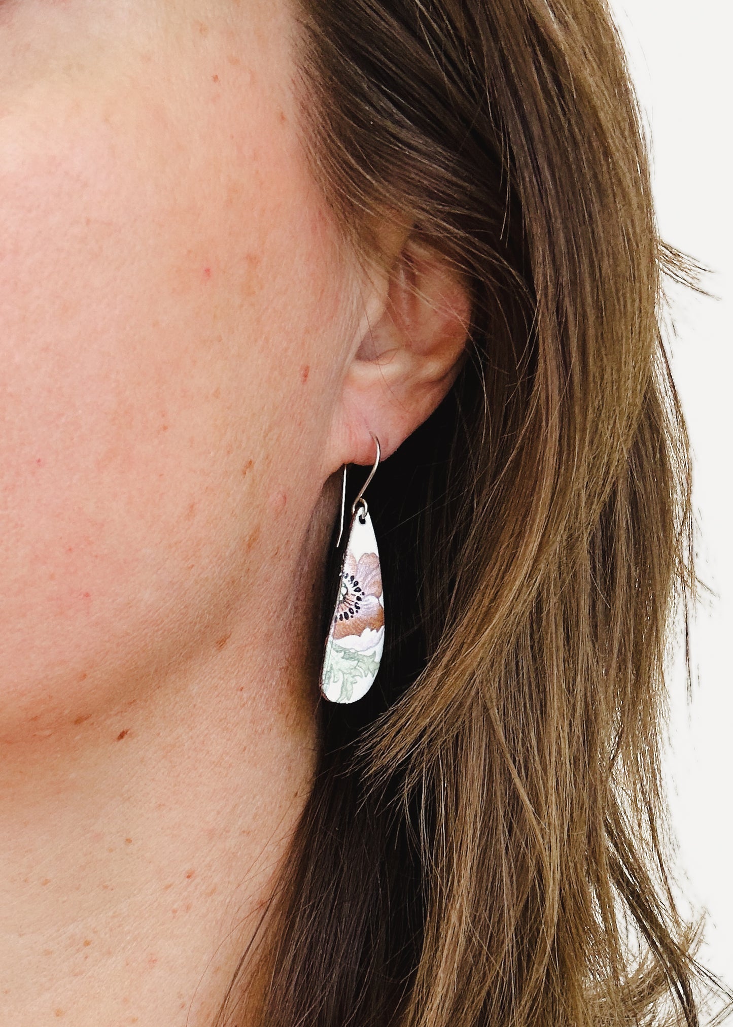 a close up of a person wearing a pair of earrings