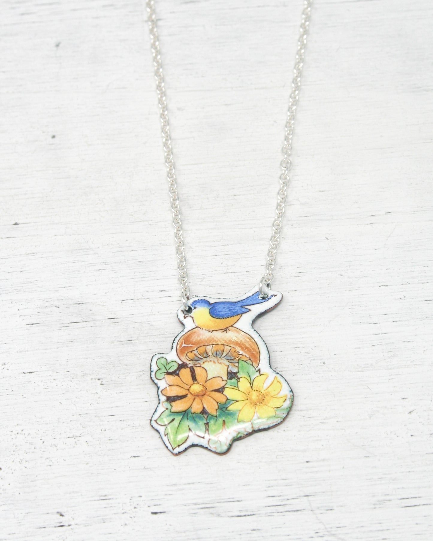 a bird sitting on top of a flower necklace