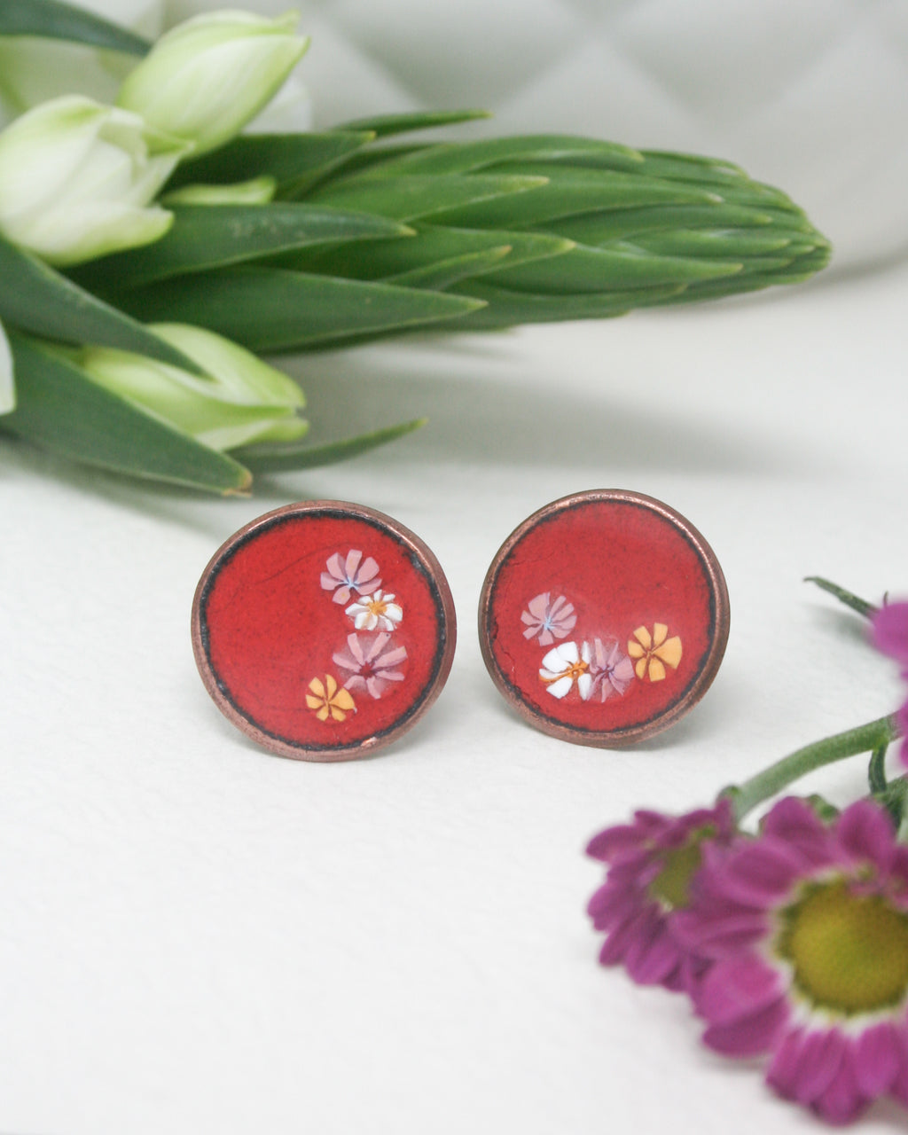 a pair of red earrings sitting on top of a table