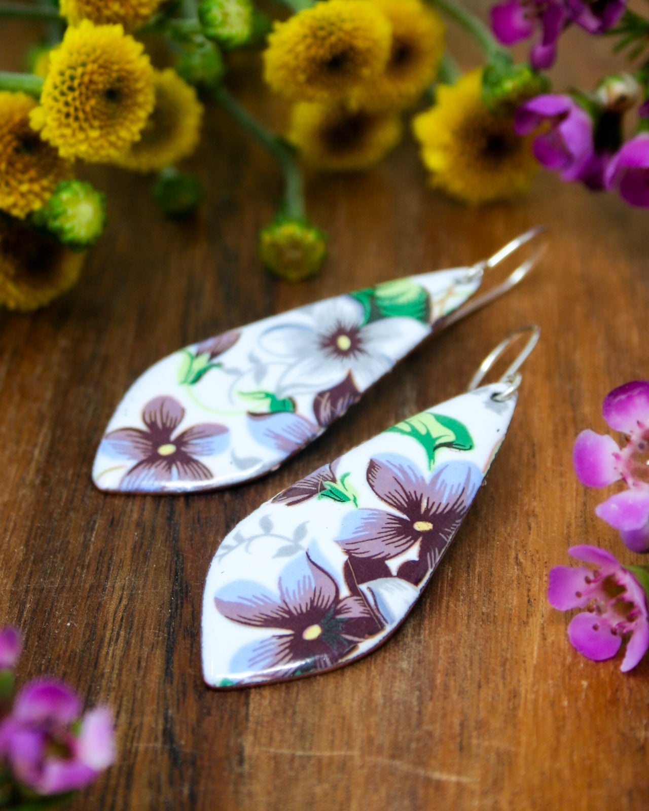 a pair of earrings sitting on top of a wooden table
