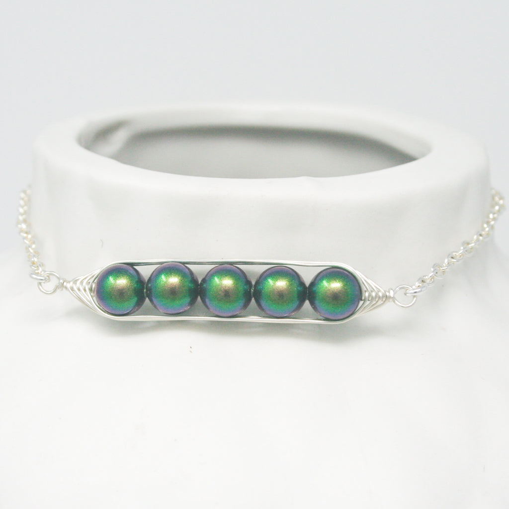 a necklace with three green beads on a chain