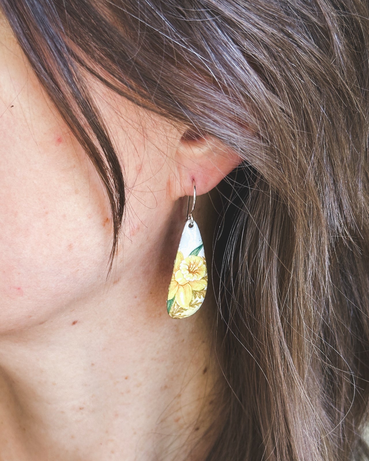 a close up of a person wearing a pair of earrings