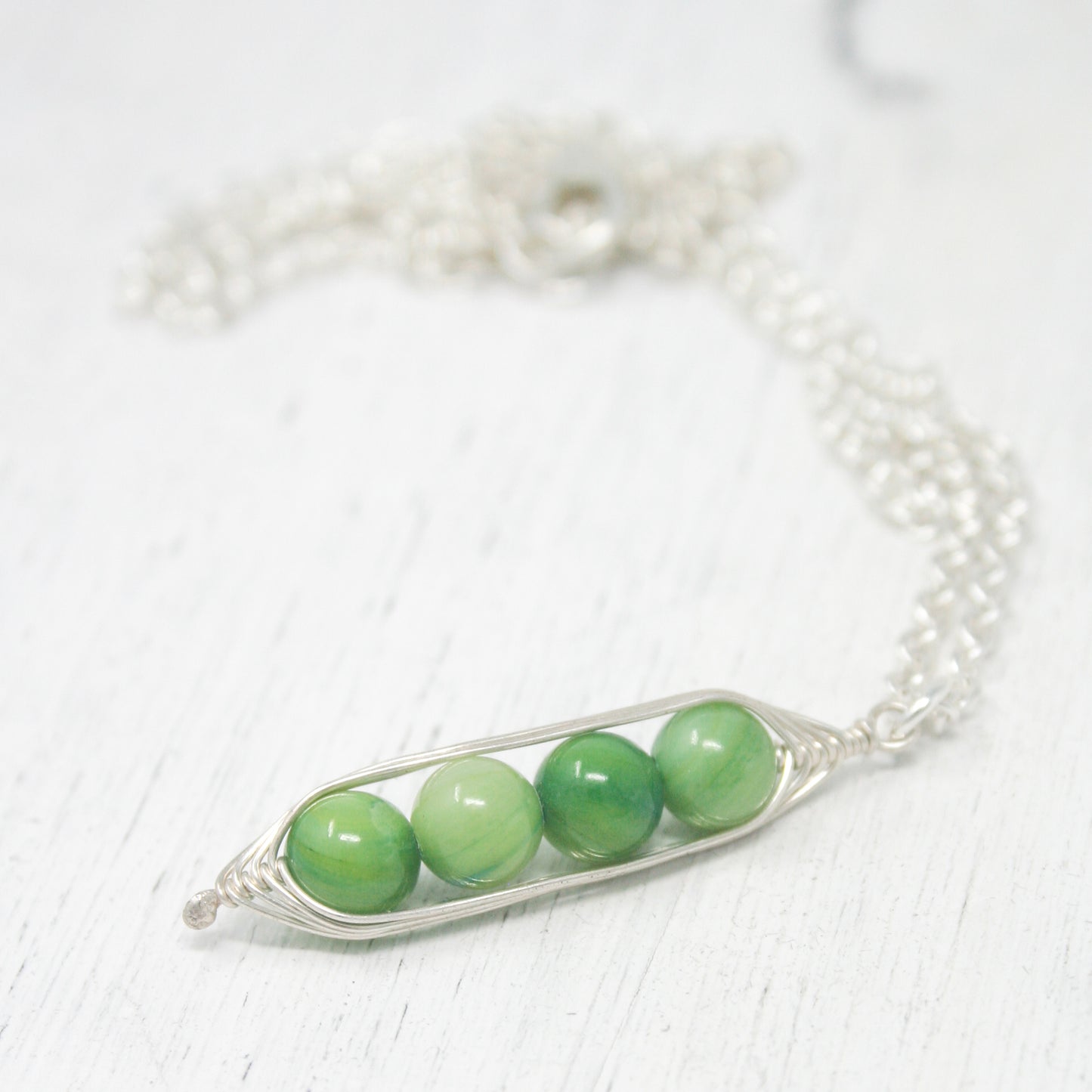 three peas in a pod on a silver chain