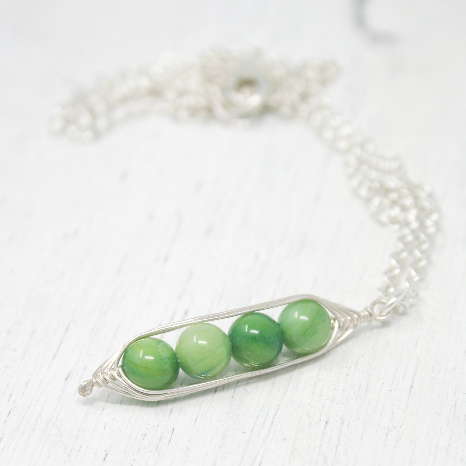 three peas in a pod on a silver chain