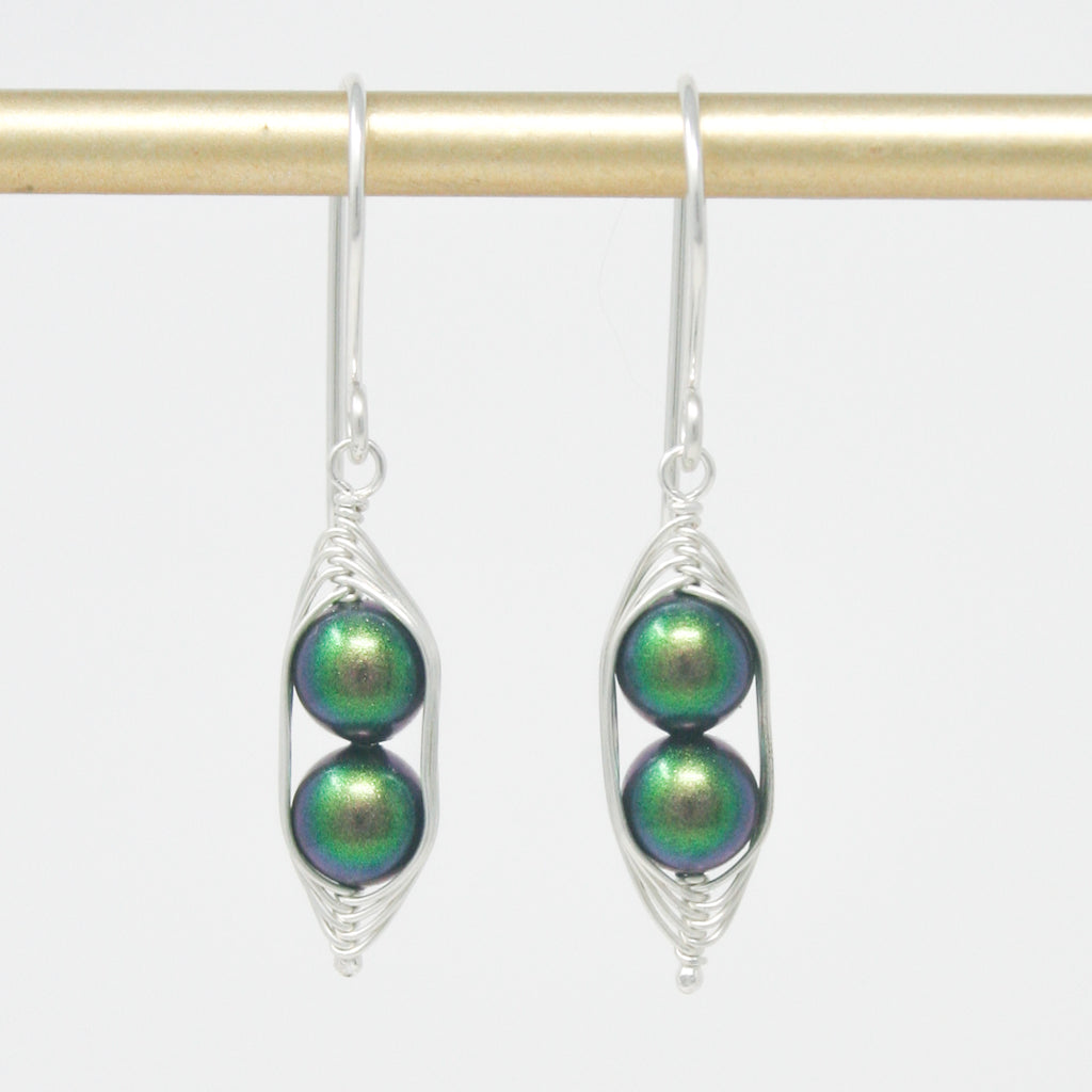a pair of earrings with green beads hanging from them