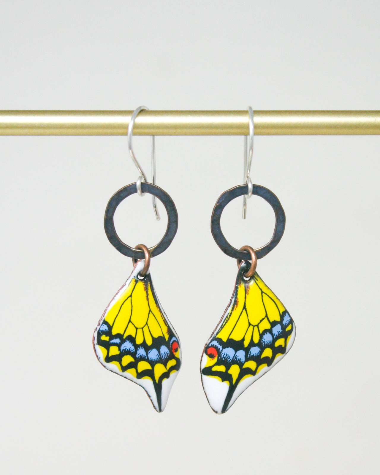 A pair of earrings with a butterfly design, featuring yellow and blue colors.